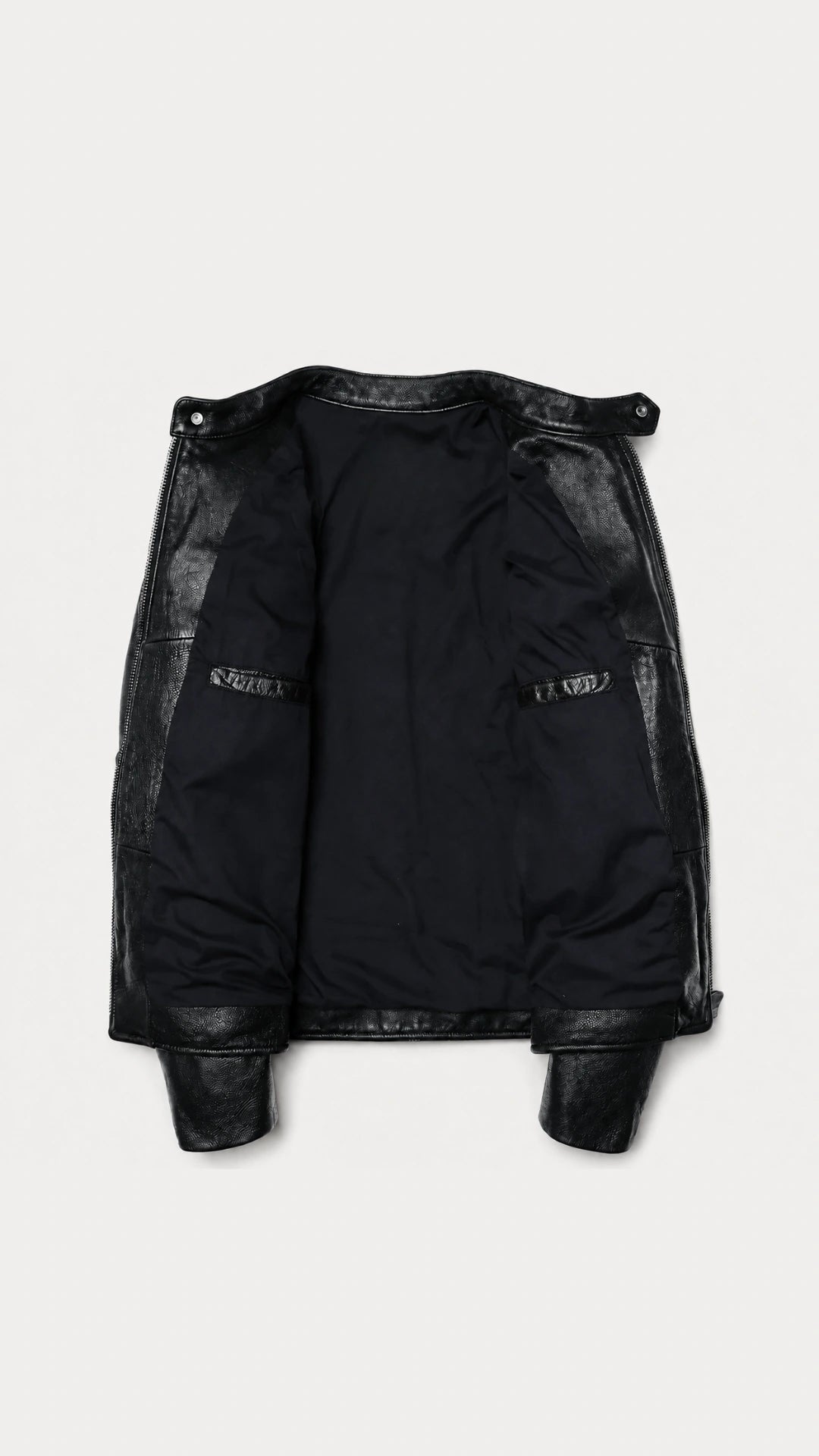 Black leather biker jacket opened flat to show the lining and inside pocket