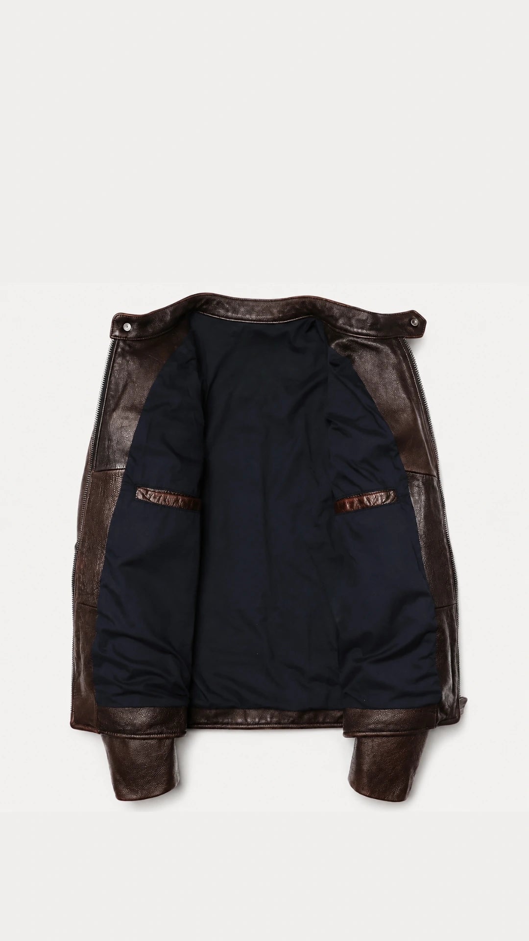 Vintage brown biker jacket opened to show the navy lining and interior pocket